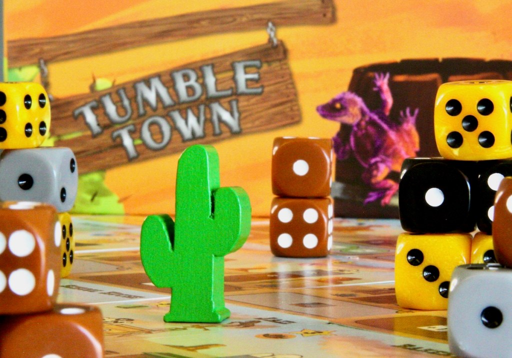 The starting token is a wooden Saguaro cactus and the buildings are made from dice in Tumble Town board game by Weird Giraffe Games