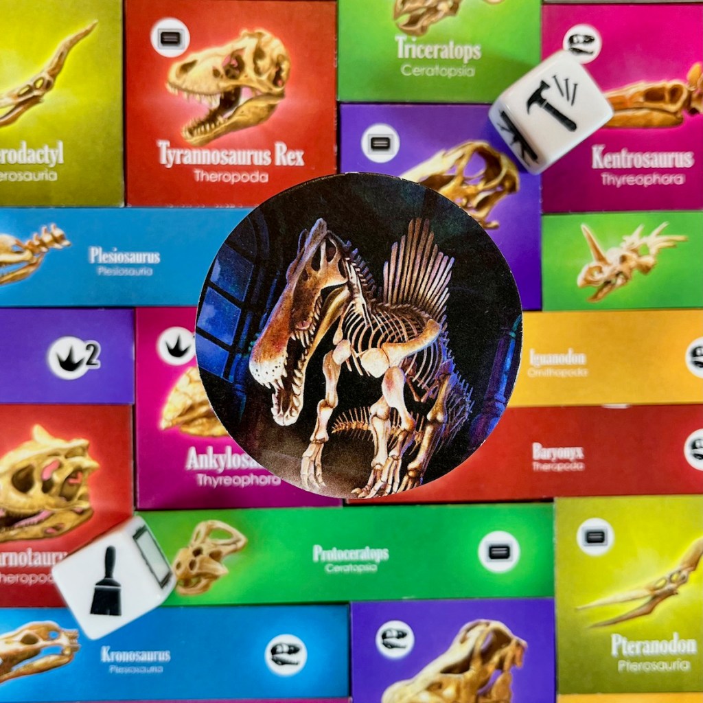 Dinosaur Exhibit Spinosaur Fossil + dice and colorful tiles in the background