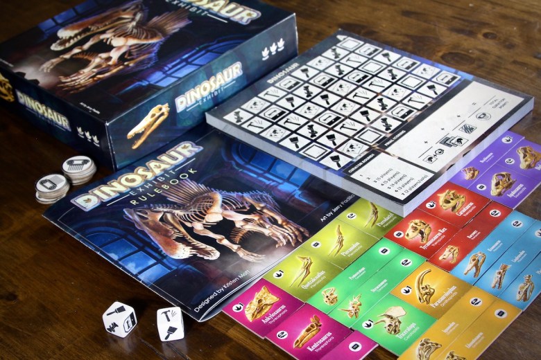 Dinosaur Exhibit components featuring tiles, dice and paper pad