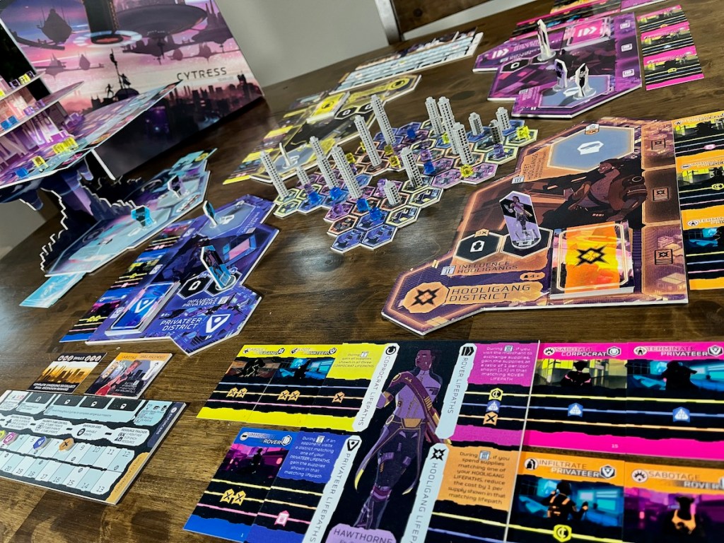 Cytress cyberpunk board game set up featuring Stratos tower, mini-map, and player boards